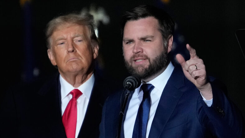 Donald Trump looks at JD Vance with a serious expression on his face