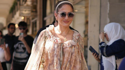 Jennifer Lopez in a bohemian style shirt and shorts shops for souvenirs.