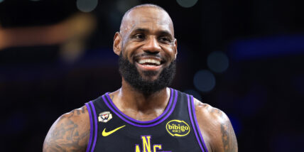 LeBron James smiling during a basketball game wearing a Lakers jersey