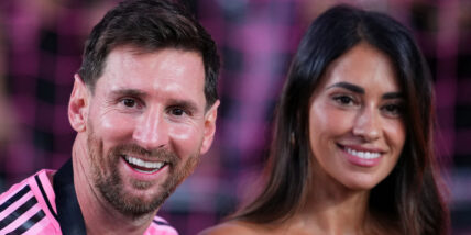 Lionel Messi and his wife Antonela posing for a photo together and smiling