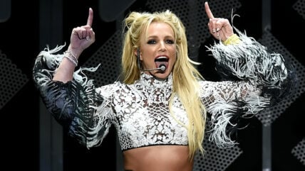 Britney Spears performs on stage in a metallic crop top.