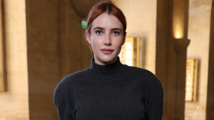 Emma Roberts wears a black sweater with her hair pulled back into a bun.