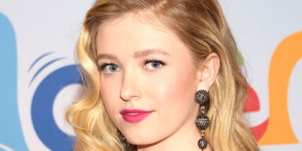 Shay Rudolph on the red carpet wearing red lipstick in a stock photo