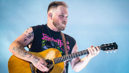 Zach Bryan performs on stage.