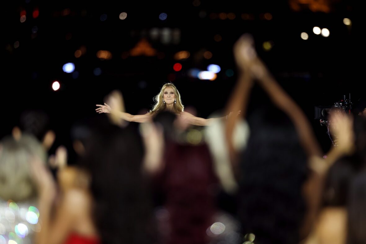 Céline Dion wears a black dress while performing on the runway at the L'Oreal show in Paris.