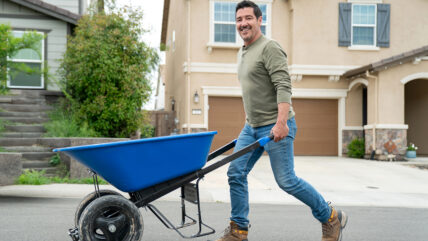 HGTV star Jonathan Knight pushing a wheelbarrow.