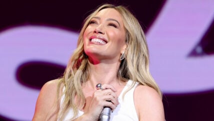Hilary Duff smiles while on stage during a concert