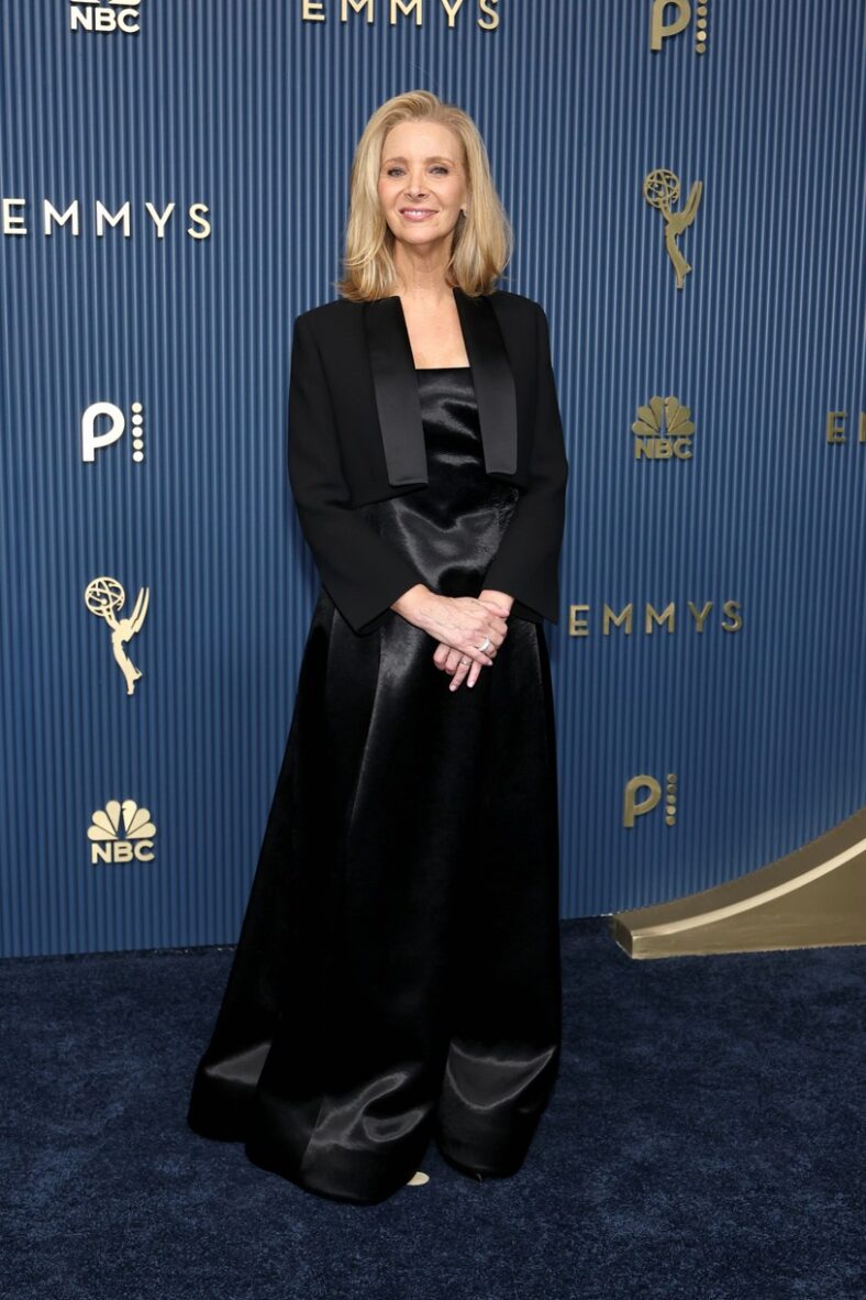 Lisa Kudrow poses with her son Julian on the 2026 Emmys red carpet. She's wearing a black satin gown with a cropped jacket and he's in a classic black suit.