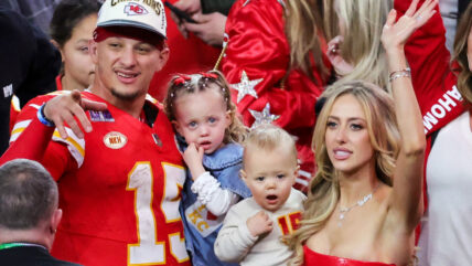 Patrick Mahomes, Brittany Mahomes, holding their kids Sterling and Bronze, on an NFL field