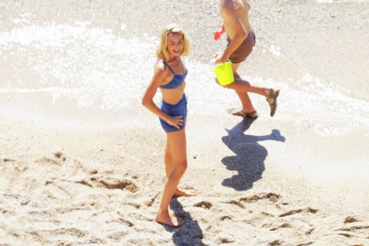 Margot Robbie and Bradley Cooper in swimsuits on beach for Ocean's Eleven prequel movie