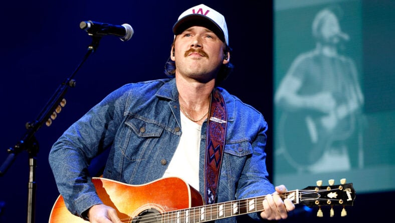 Morgan Wallen playing guitar on stage