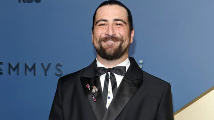 Noah Kahan on the 2026 Emmys red carpet wearing a black double-breasted tuxedo with satin lapels and a black bow tie.