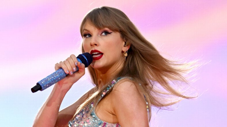 Taylor Swift performing on Eras tour with pink background