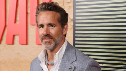 Ryan Reynolds in necklace and gray suit at Mayday premiere