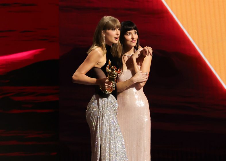 Taylor Swift accepts an award on stage with Dakota Johnson at the 2026 MTV VMAs