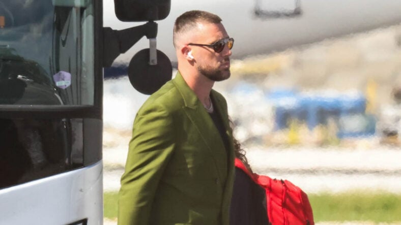 Travis Kelce in a green suit at the airport