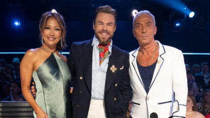 Carrie Ann Inaba, Derek Hough, and Bruno Tonioli pose at the judges panel on DWTS