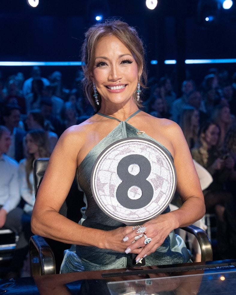 Carrie Ann Inaba poses with her score padel on DWTS
