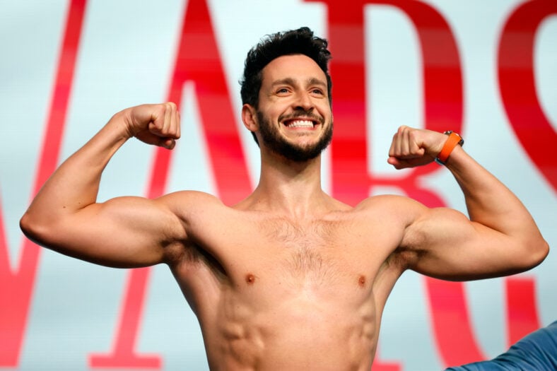 Dr Mike shirtless posing with his biceps flexed