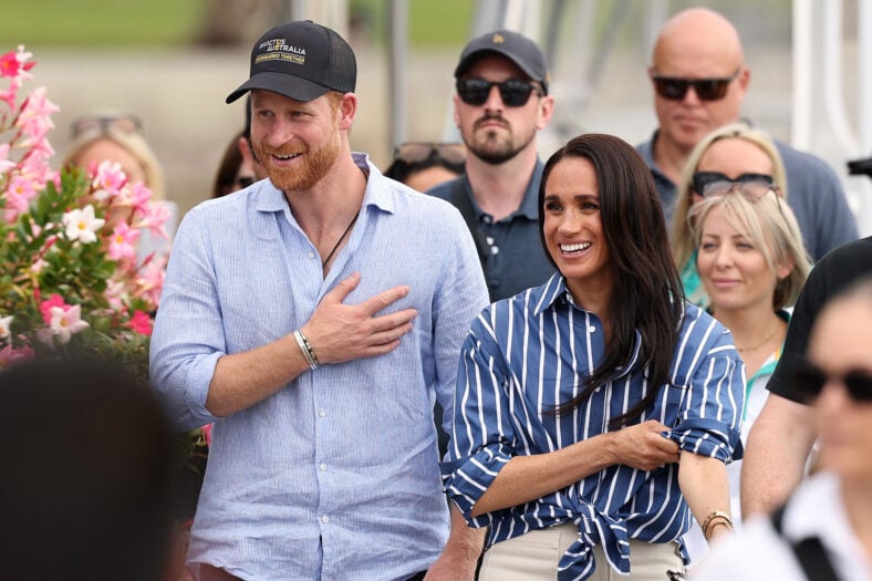 Prince Harry & Meghan Markle during a past appearance together, smiling and greeting onlookers