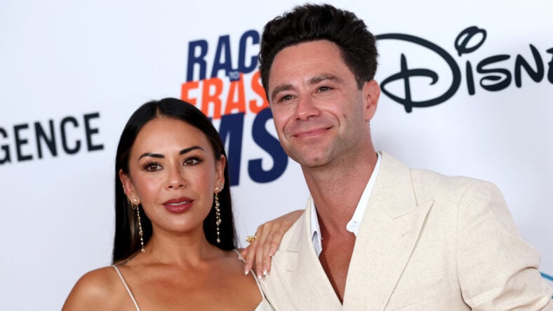 Janel Parrish and Sasha Farber at an event coordinating in white outfits. They are posing together
