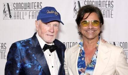 John Stamos and Mike Love posing on red carpet