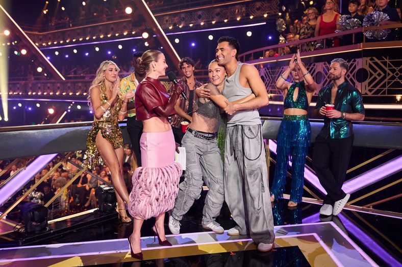 Still of Julia Stiles and Ezra Sosa with Julianne Hough on DWTS Super Bowl Night