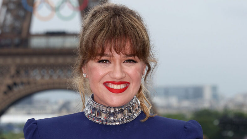 Kelly Clarkson in front of the Eiffel Tower, smiling