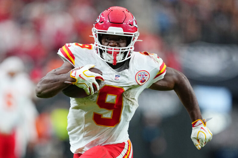 Kenneth Walker in a Chiefs game, holding a football and running towards the camera