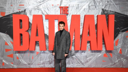 The Batman logo, Robert Pattinson standing right in front of it. 2022 Stock Image