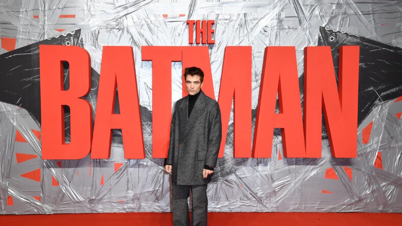 The Batman logo, Robert Pattinson standing right in front of it. 2022 Stock Image