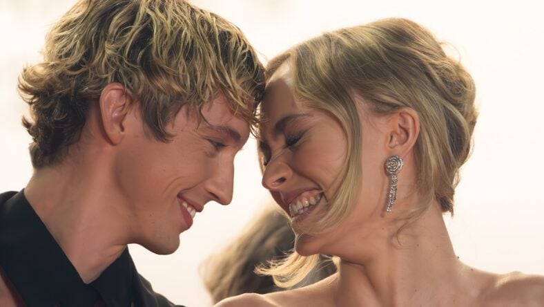 Troye Sivan and Lily-Rose Depp smiling holding heads together