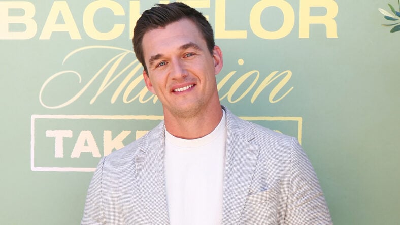 Tyler Cameron in a gray suit at an event for Bachelor Nation.